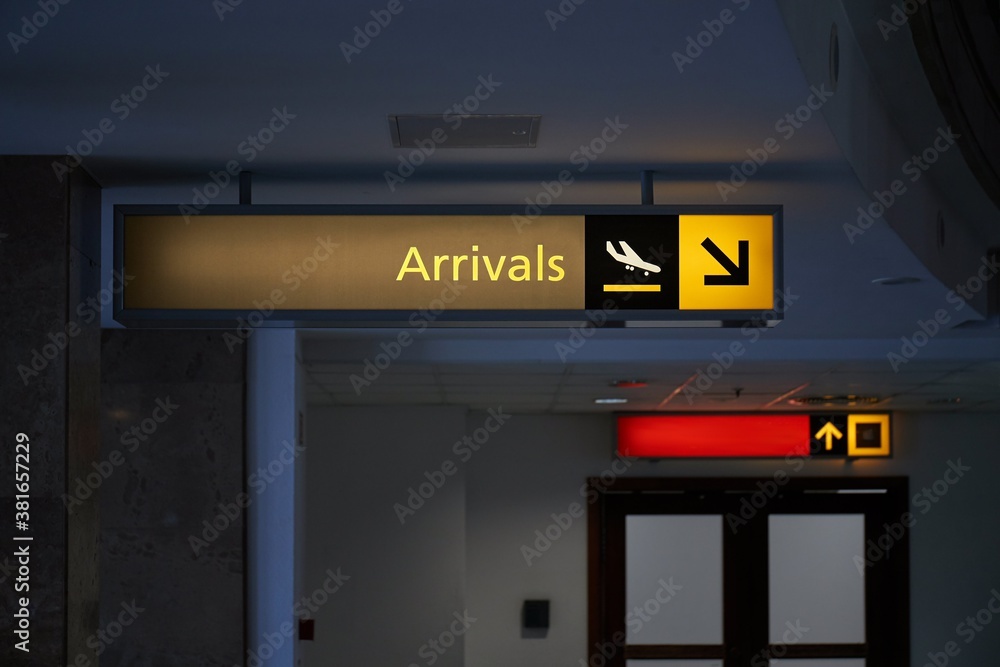 Arrival hall sign at an airport with dim light and no people Arrival hall sign at an airport with dim light and no people