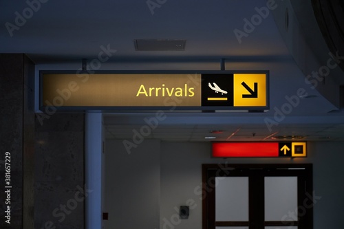 Arrival hall sign at an airport with dim light and no people