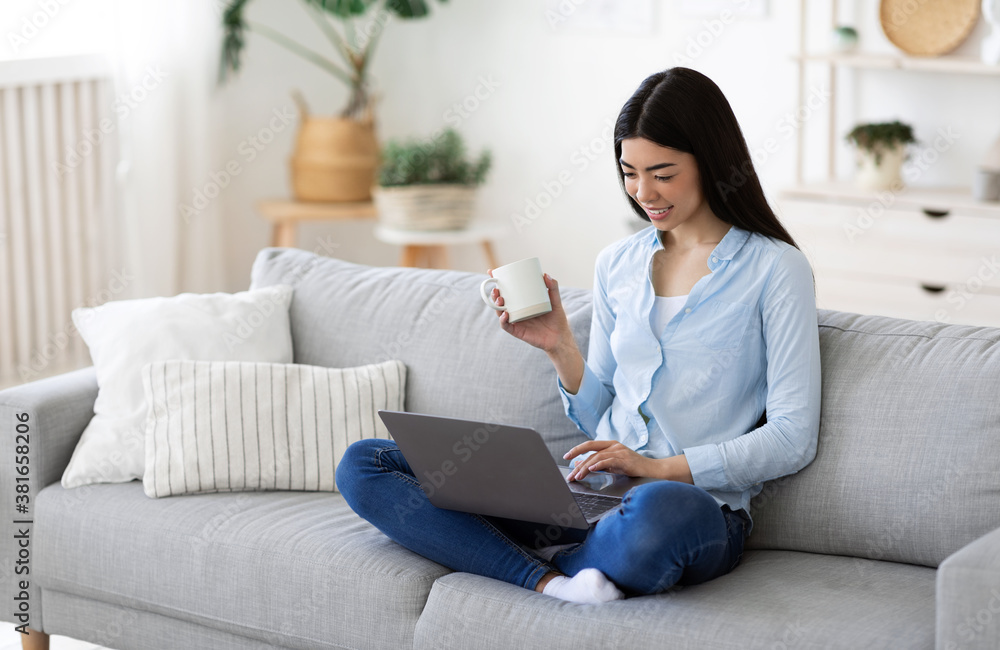 Free Time At Home. Smiling Korean Lady Relaxing In Living Room Free Time At Home. Smiling Korean Lady Relaxing In Living Room