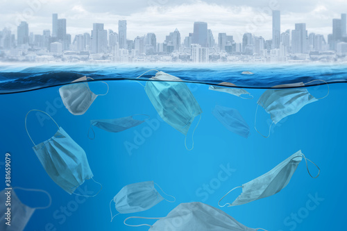 Garbage face mask floating in the sea montage photo with a city picture   COVID-19 global pandemic is prompting increased consumption of single-use plastics