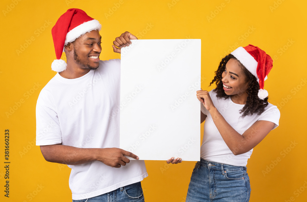Black Couple Holding Blank Board Wearing Christmas Hats, Yellow Background