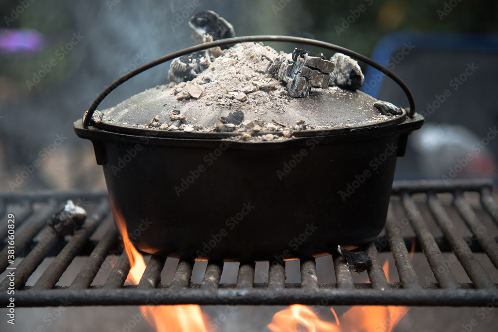 Cooking in a cast iron Dutch oven over a campfire. Cooking in a cast iron Dutch oven over a campfire.