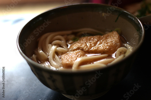 Close up of a bowl of delicious tofu (bean curd) udon (Japanese noodles), soft focus