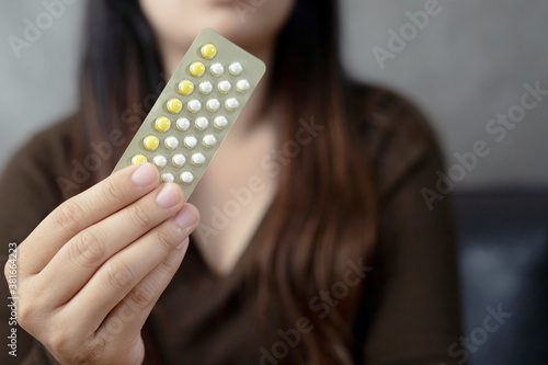 Women holding birth control pills,focus hand