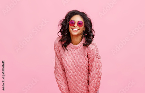 Happy ethnic woman in sunglasses laughing.