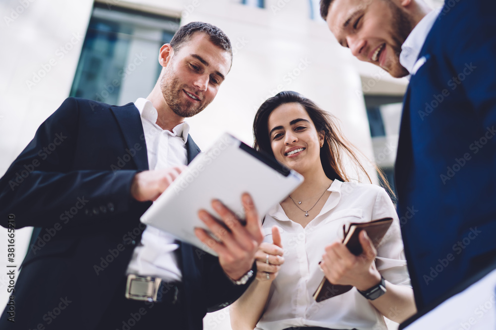 Cheerful diverse colleagues working on tablet Cheerful diverse colleagues working on tablet
