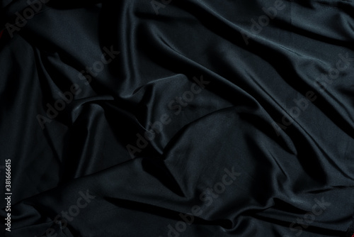 Crumpled textile fabric background of black color.