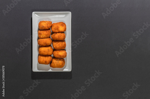Fried Spanish ham Croquettes over a black background photo