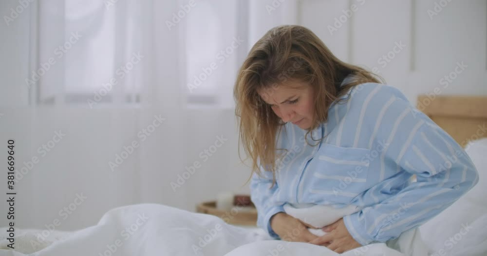 Stomachache. The redhead girl has awful stomachache at her home. Abdominal pain. Her menstrual cramps are too painful to go to work Stomachache. The redhead girl has awful stomachache at her home. Abdominal pain. Her menstrual cramps are too painful to go to work