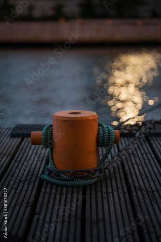 Bollard at harbor with water in the background