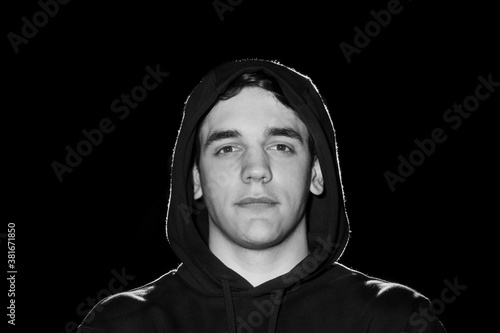 Black and white portrait of a guy with hood on his had.