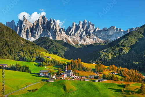 Famous Alpe di Siusi - Seiser Alm with Sassolungo - Langkofel mountain group in background at sunset. Wooden chalets in Dolomites, Trentino Alto Adige region, South Tyrol, Italy