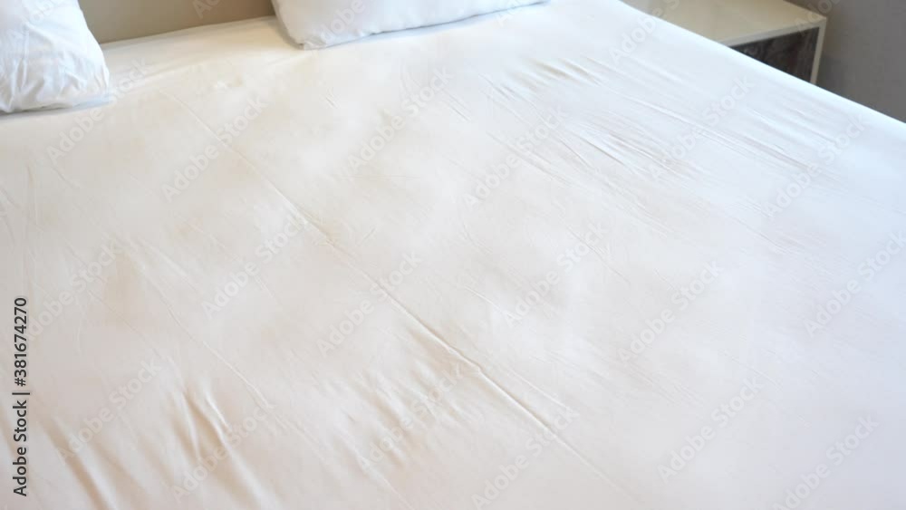 Cute two white swans made by towels laying on bed in hotel room Cute two white swans made by towels laying on bed in hotel room