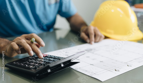 civil male engineer working on blueprint architectural project at desk in office