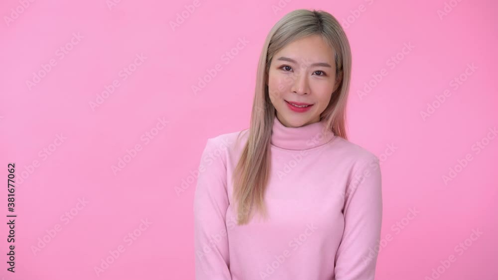 Cute asian woman look a camera on pink background 4k resolution Cute asian woman look a camera on pink background 4k resolution