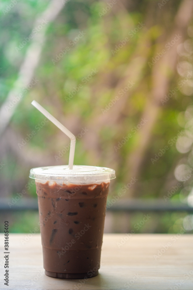 Iced coffee Mocha in disposable plastic cup on wood table Iced coffee Mocha in disposable plastic cup on wood table