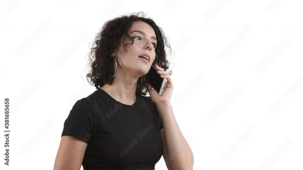 Attractive caucasian woman with short curly hair, wearing black t-shirt, tap mobile phone screen to dile a number, calling someone, smiling while waiting for reply, standing over white background Attractive caucasian woman with short curly hair, wearing black t-shirt, tap mobile phone screen to dile a number, calling someone, smiling while waiting for reply, standing over white background