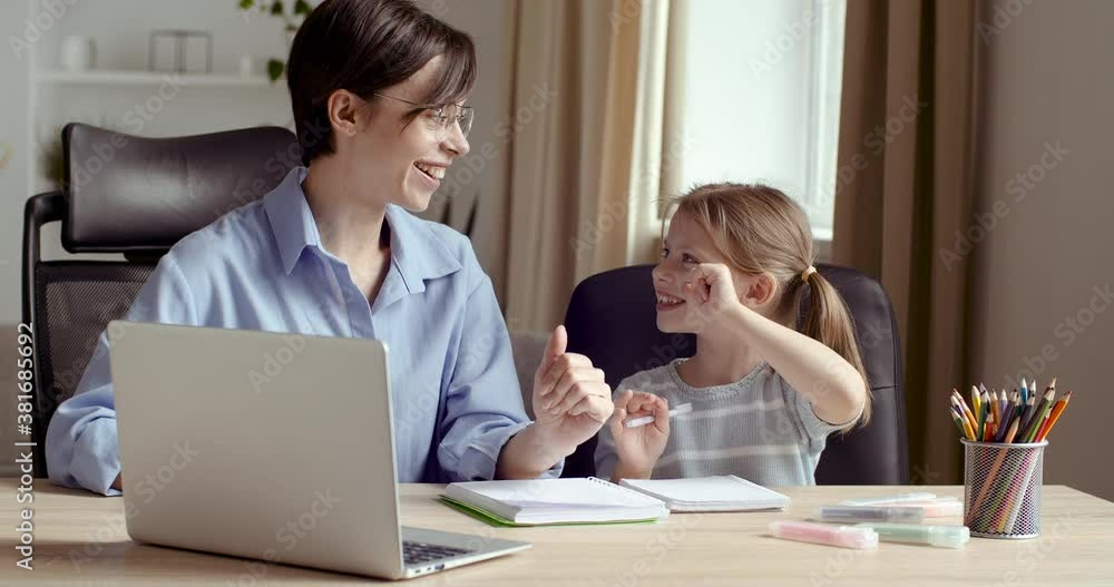 Happy family adult parent mother helping motivating teenage school girl doing homework giving high five. Positive mom and teen daughter studying together having fun sitting at home desk in home room Happy family adult parent mother helping motivating teenage school girl doing homework giving high five. Positive mom and teen daughter studying together having fun sitting at home desk in home room