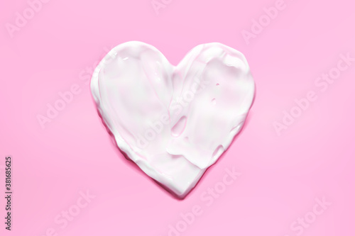 Heart moisturizer cream smear on pink background realistic illustration, top view. Concept skincare. Lotion for face or body photo