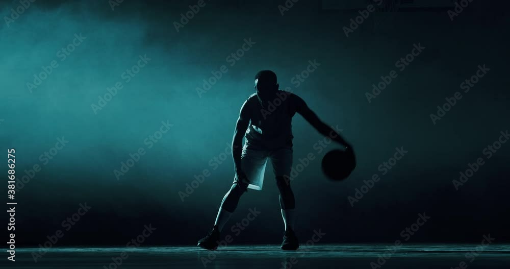 Cinematic slow motion back view shot of young professional male players are walking towards a basket before to start practicing a basketball work out in a gym. Cinematic slow motion back view shot of young professional male players are walking towards a basket before to start practicing a basketball work out in a gym.