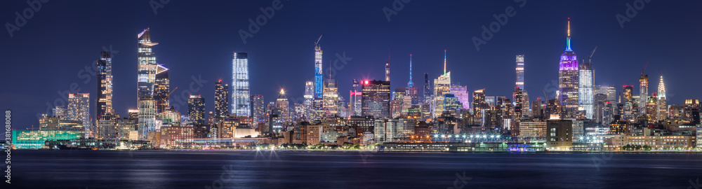 New York CIty panoramic cityscape of Midtown West skyscrapers at night along Hudson River Park. Manhattan, NY, USA