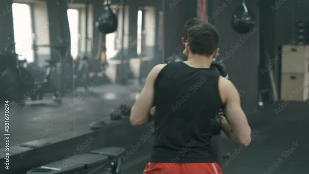 Athletic man fighting during the training with boxing trainer at the gym. 4K slow motion Athletic man fighting during the training with boxing trainer at the gym. 4K slow motion