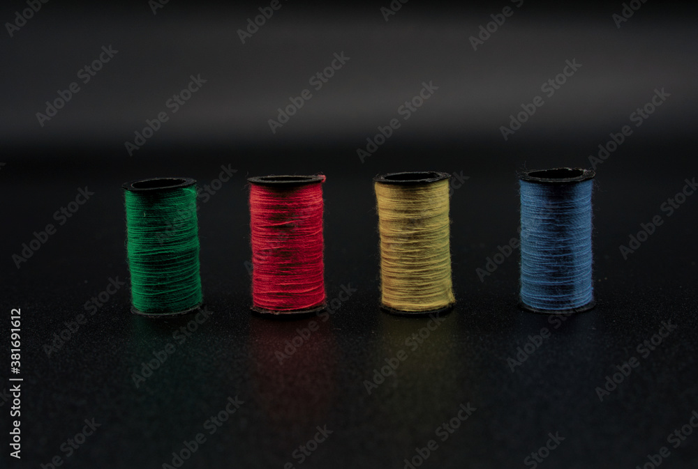 View of colored sewing threads on black background. Sewing concept. View of colored sewing threads on black background. Sewing concept.