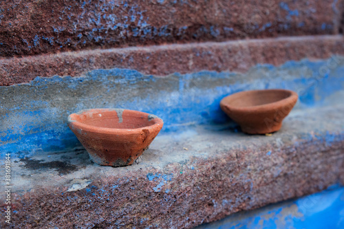 Oil Lamp Pooja Diya Lamp on blue house wall in street of Jodhpur, Rajasthan, India photo