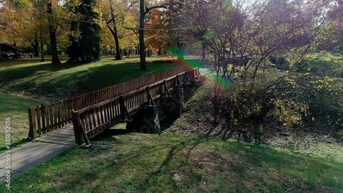 A lens flare crests over a footbridge in a local park photo