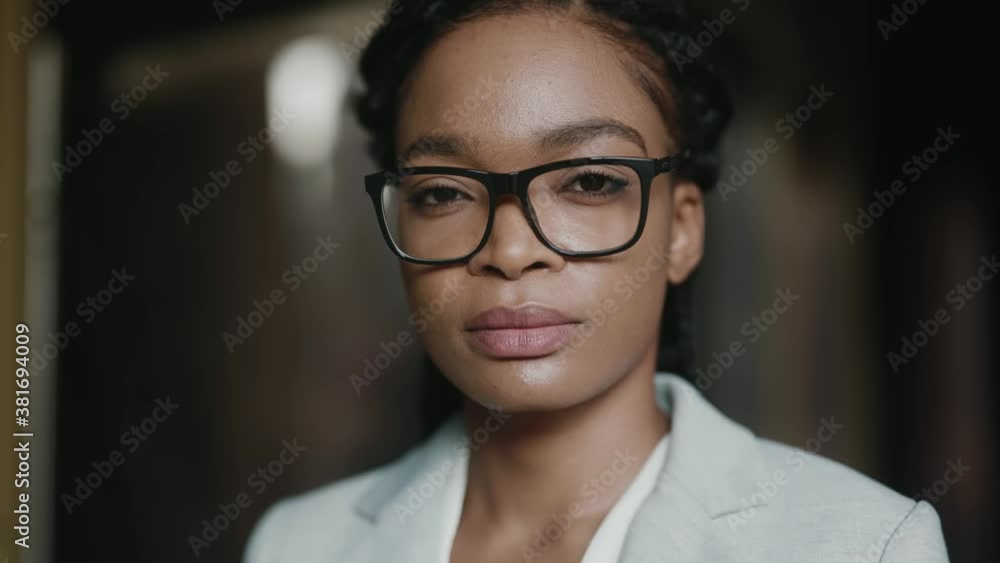 Outdoor portrait of beautiful black woman smart face eyeglasses looking serious into camera. Sunshine in background. Successful people. Businesswoman. Corporate. Outdoor portrait of beautiful black woman smart face eyeglasses looking serious into camera. Sunshine in background. Successful people. Businesswoman. Corporate.