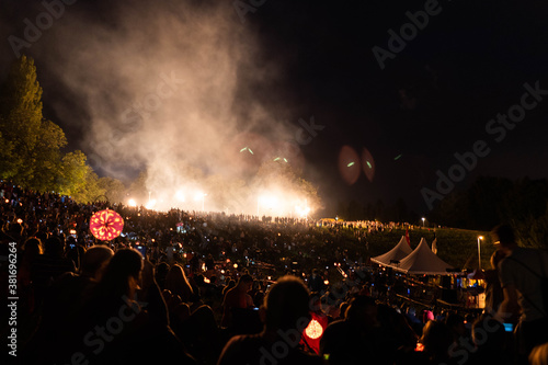 people dancing at the concert with fires lighting the night sky