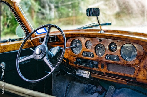 Interior dashboard of luxury, vintage, classic car with wood panelling.