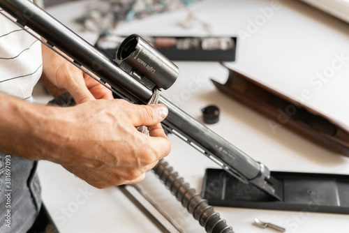 man's hands disassemble the classic shooting weapon rifle, sport hunting concept