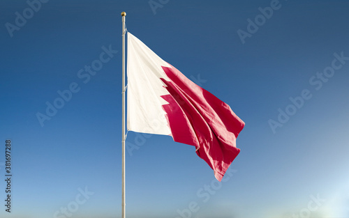 Quatar national flag waving against blue sky background. Isolated.