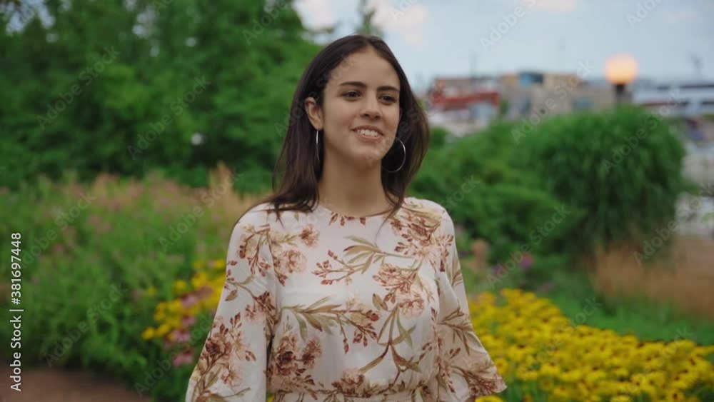 Elegant young brunette woman walking through a lush green lakeside park on a warm summer evening, SLOW MOTION Elegant young brunette woman walking through a lush green lakeside park on a warm summer evening, SLOW MOTION