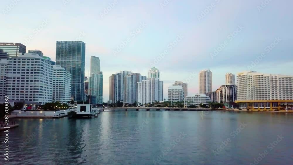 Aerial view low over the sea towards skyscrapers and the Brickell key bridge, during sunrise, in Miami, Florida, USA - dolly, drone shot Aerial view low over the sea towards skyscrapers and the Brickell key bridge, during sunrise, in Miami, Florida, USA - dolly, drone shot