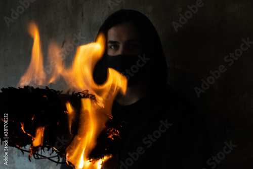 YOUNG MAN WITH FIRE TORCH IN URBAN EXPLORATION URBEX