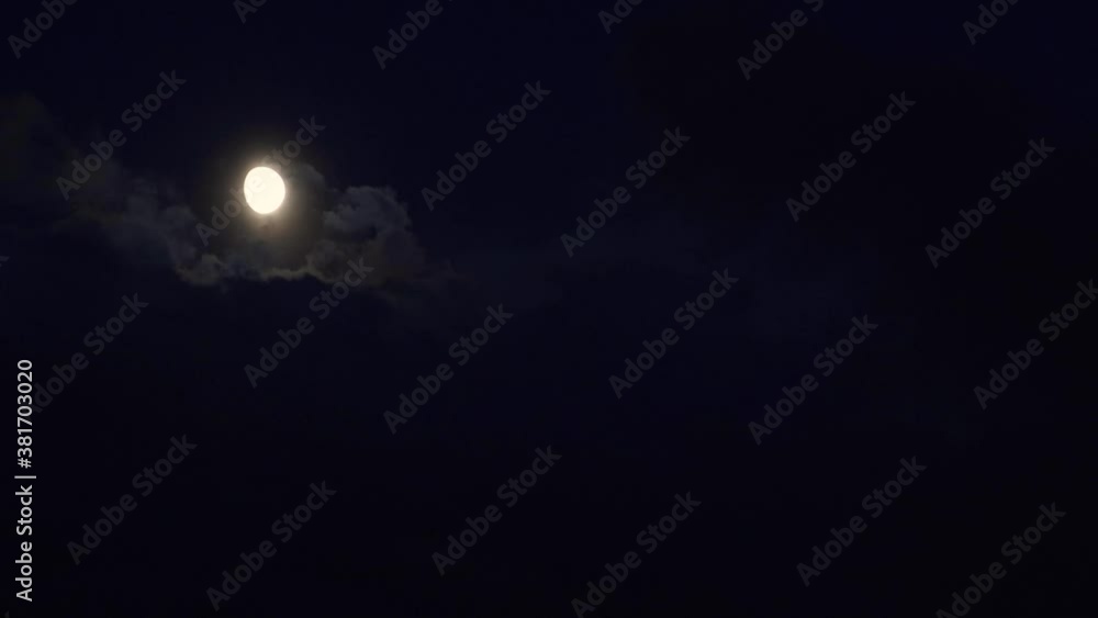 Timelapse of clouds moving in front of moon in dark night sky Timelapse of clouds moving in front of moon in dark night sky