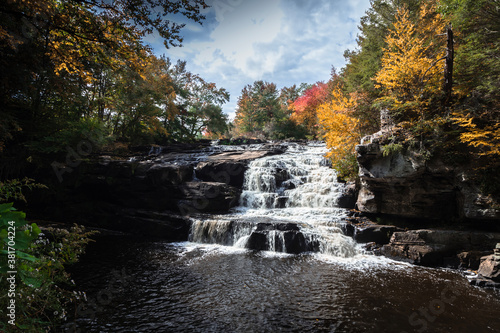 Brilliant fall foliage surrounds the beautiful cascading Shohola Falls in the Pennsylvania Poconos © rabbitti