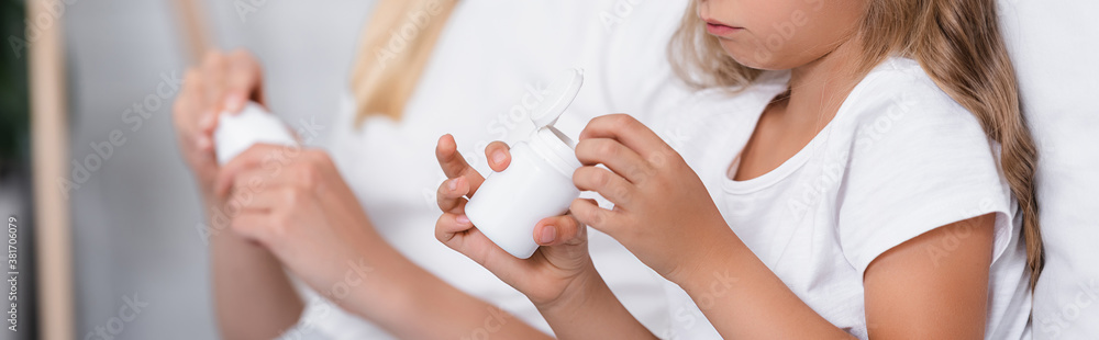 Website header of girl holding jar with pills near woman at home Website header of girl holding jar with pills near woman at home