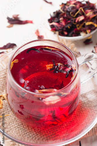 Cup of fresh red tea on white wooden background