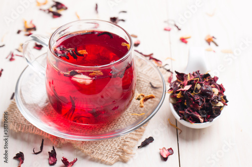 Cup of fresh red tea on white wooden background