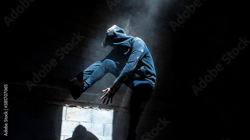 YOUNG MAN JUMPING ON DUST IN URBAN EXPLORATION URBEX