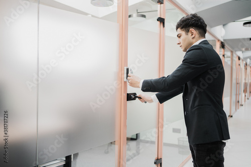 a young man of Caucasian appearance opens the door with his feet in a business suit. they try to get you to work in the office. late for a meeting