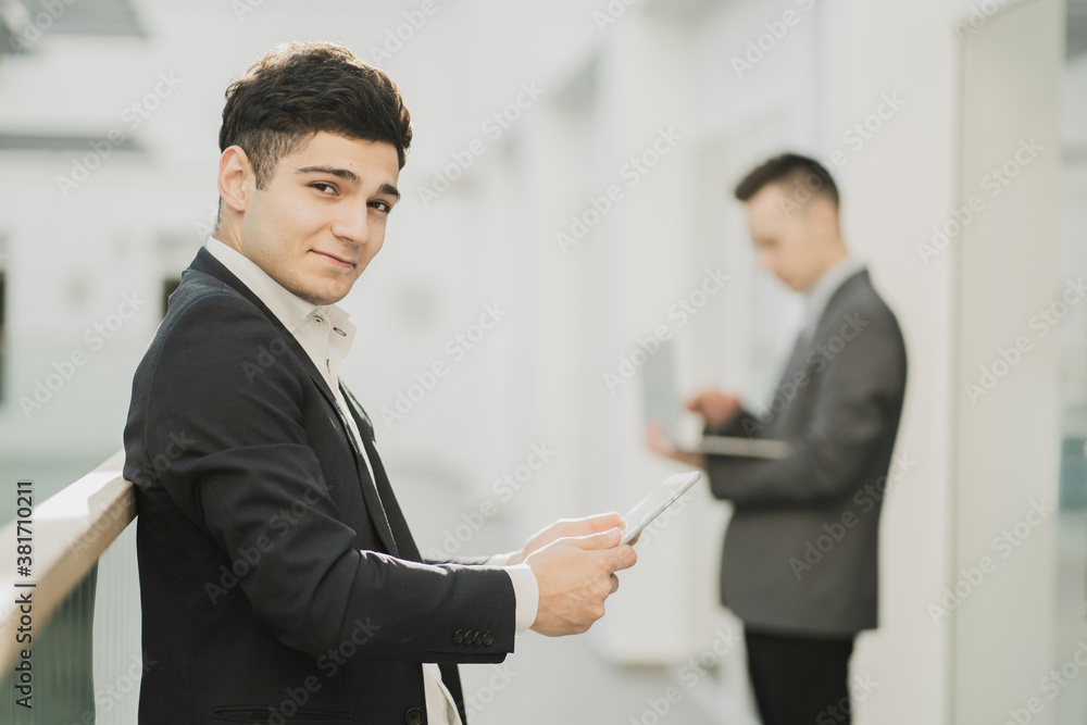 portrait of professional businessmen men of young appearance works on gadgets. create new projects online an interesting idea. European appearance, stylish office, working mood portrait of professional businessmen men of young appearance works on gadgets. create new projects online an interesting idea. European appearance, stylish office, working mood