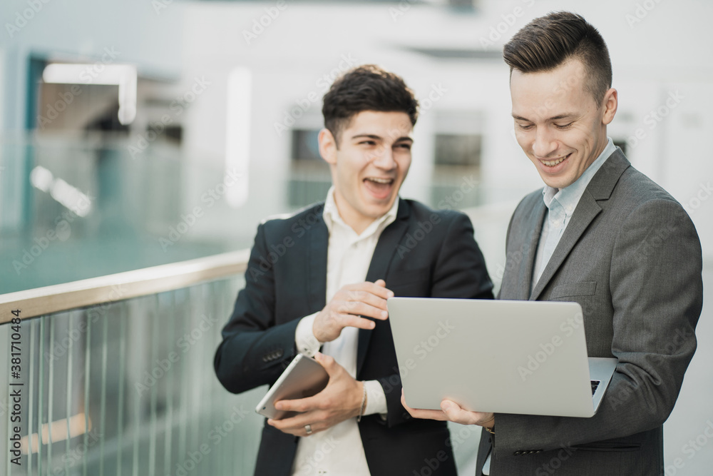 Partners business suits businessmen are working in the office looking at a laptop planning the future strategy of their business. Partners business suits businessmen are working in the office looking at a laptop planning the future strategy of their business.
