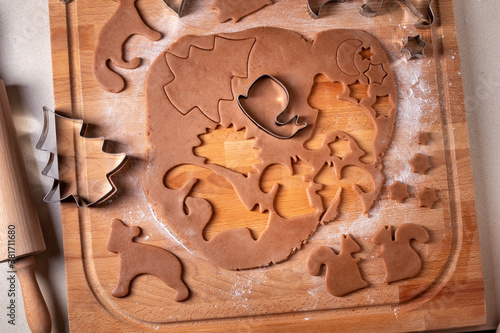 Cutting out shapes from dough for gingerbread Christmas cookies