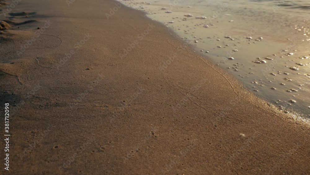 Golden, sandy beach and waves rolling on shore