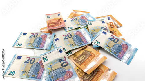 several Euro cash banknotes scattered on the white background