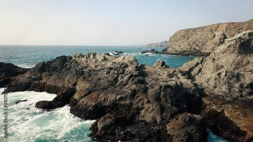 Aerial view of ocean waves crashing the California rocky coast. Aerial view of ocean waves crashing the California rocky coast.